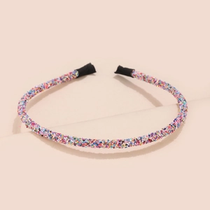 Close-up of glitter sequins on a thin festive headband with black protective tips