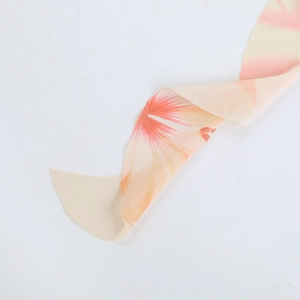 Macro view of breathable mesh fabric featuring pink and orange floral patterns