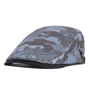 Detail of blue camouflage beret cap with black brim and metal side adjustment buckle
