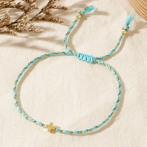 Detailed close-up of handmade woven cross bracelet with blue and yellow threads