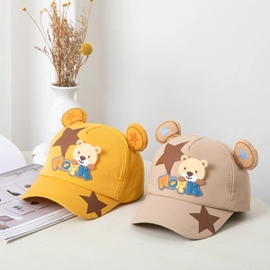 Détail de casquettes de baseball jaune et kaki à oreilles d'ours avec patch et étoiles