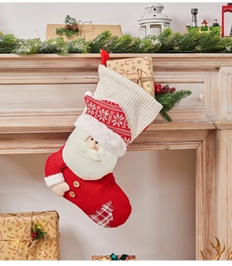 Close-up of a red knitted Christmas stocking with 3D Santa hanging on a decorated fireplace
