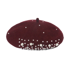 Close-up of wine red wool beret featuring elegant pearls and sparkling rhinestones