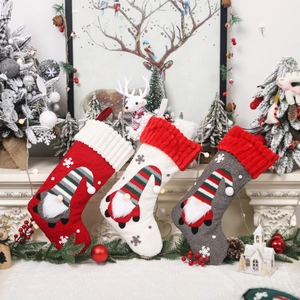 Three Christmas gnome stockings in red, white and grey with snowflake embroidery