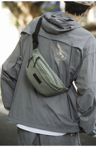 Detail of light green waterproof crossbody bag with dual zippers and adjustable strap
