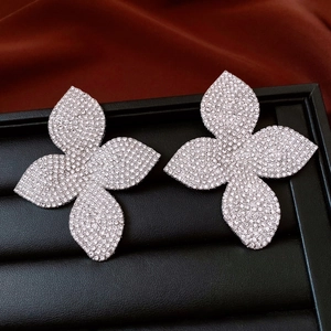 Vue détaillée des boucles d'oreilles fleur argentées serties de diamants sur plateau