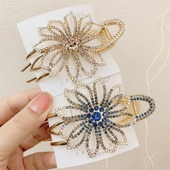 Detail of crystal flower hair claws with gold finish and rhinestones on a card