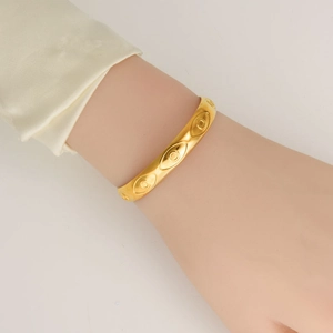 Minimalist 18K gold plated stainless steel evil eye bangle with relief patterns