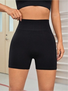 Detail of high-waisted seamless black yoga shorts with elastic tummy control waistband