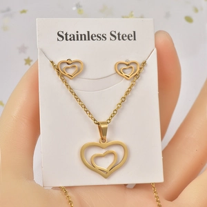 Detail of a gold heart jewelry set with necklace and earrings held on a display card