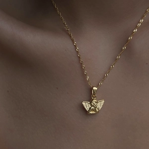 Close-up of gold titanium steel necklace featuring a crystal-set angel cherub pendant