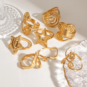 Detailed view of 8-piece gold spiral and hollow star rings set with metallic luster