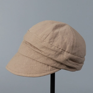Detail view of khaki linen pleated newsboy cap with breathable fabric and short brim