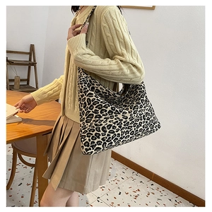 Detailed view of a large leopard print tote bag styled with a beige knit outfit