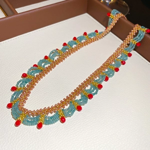Ethnic bohemian style beaded necklace with light blue and red crystal beads in woven design