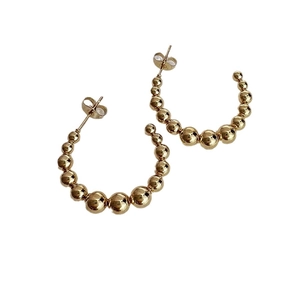 Minimalistische goldene C-Creolen mit abgestuften Edelstahlperlen auf weißem Hintergrund