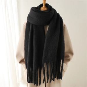 Gros plan sur une écharpe en mohair noir avec franges épaisses sur un manteau beige