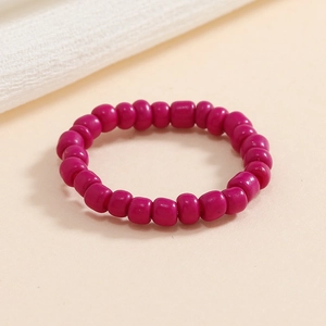 Vista macro di un anello elastico con perline fucsia e perle dalla lucentezza naturale