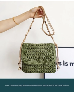 Detail of hand-woven straw crossbody bag in grass green with wooden bead strap