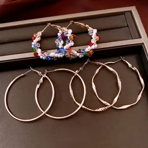 Three pairs of vintage pearl beaded hoop earrings and twisted gold metal rings set