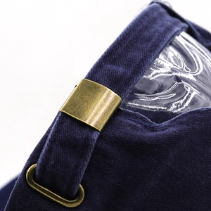 Detail of adjustable brass buckle and metal eyelet on a navy cotton baseball cap
