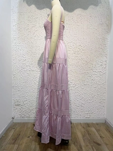 Detail of pink and white striped maxi dress featuring tiered ruffles and smocked bodice