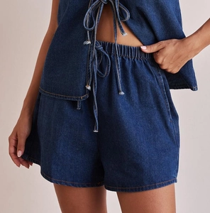 Detail view of dark blue denim set showing tie-up sleeveless top and drawstring shorts