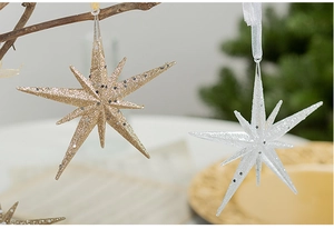 Detail of champagne and silver star ornaments with glitter on tree branches