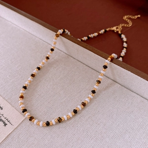Detail of floral beaded necklace with tiger eye stones and gold lobster clasp