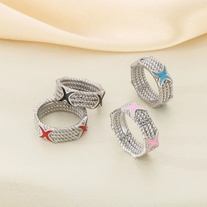 Classic braided rope rings with colorful enamel X details on warm satin background