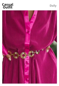Detailed shot of a gold metallic circle belt paired with a pleated fuchsia dress for women