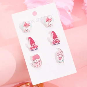 Detail shot of cute gnome-themed Valentine stud earrings set on a pink display card