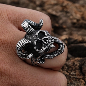 Gothic ram skull ring in retro oxidized stainless steel worn on hand with dark backdrop