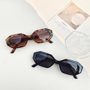 Detail of retro geometric sunglasses in tortoiseshell and black frames with gradient lenses