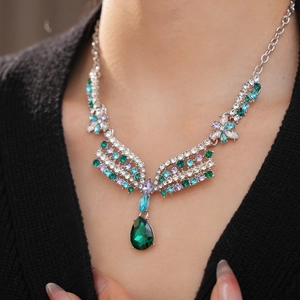 Detailed macro view of a vintage flower necklace with green teardrop crystal pendant