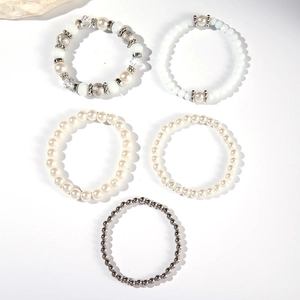 Dettaglio del set di cinque braccialetti in argento e perle con cristalli e metallo