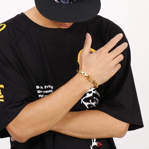 Detail shot of a men's heavy industrial style gold link chain bracelet on a wrist