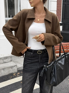 Scatto street style di una giacca di lana marrone con zip e colletto in città