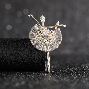 Detailed macro view of a golden ballet dancer brooch with sparkling crystal embellishments