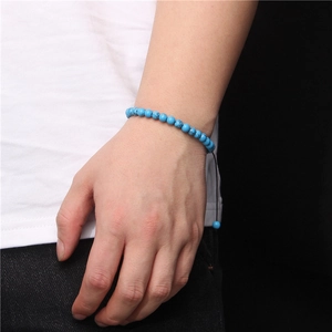 Macro detail of hand-woven bracelet featuring 6mm turquoise beads and adjustable cord