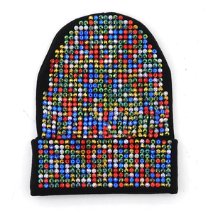 Dettaglio di strass colorati su berretto in maglia acrilica nera spessa per l'inverno