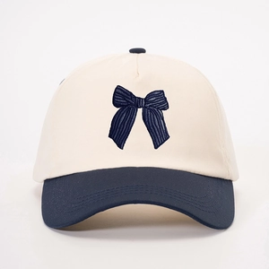 Dettaglio del ricamo a fiocco e del design a contrasto su un cappello di cotone