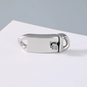 Detailed macro view of polished silver stainless steel fold-over clasp for Cuban chain links