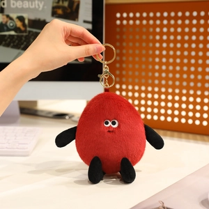 Detail of creative red peanut plush keychain with cute big eyes and golden metal clip