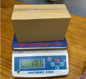 Measurement of wooden desk calendar in brown cardboard box on electronic scale