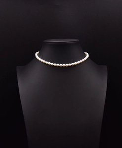 Detail of natural freshwater pearl choker necklace on a minimalist black display stand