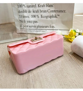 Pink jelly bag with diamond lattice pattern and golden lock in a stylish lifestyle setting