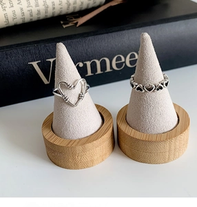 Macro detail of S925 sterling silver hollow heart rings on wooden cone displays