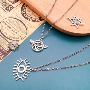 Antique silver Eye of Horus alloy pendants on wood tray with blue background
