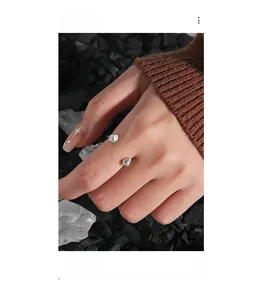 Detail shot of irregular textured S925 sterling silver open ring on finger